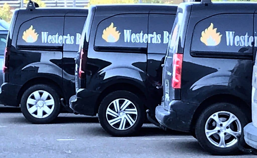 Tre Westerås Brand-bilar uppradade på en parkering.